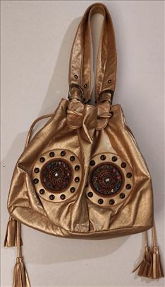 U hipi stilu bogato ukrasena zlatna torba