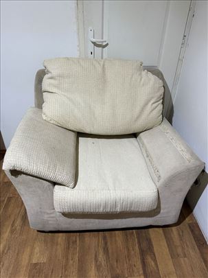 Velika bela fotelja  dva jastuka uz nju